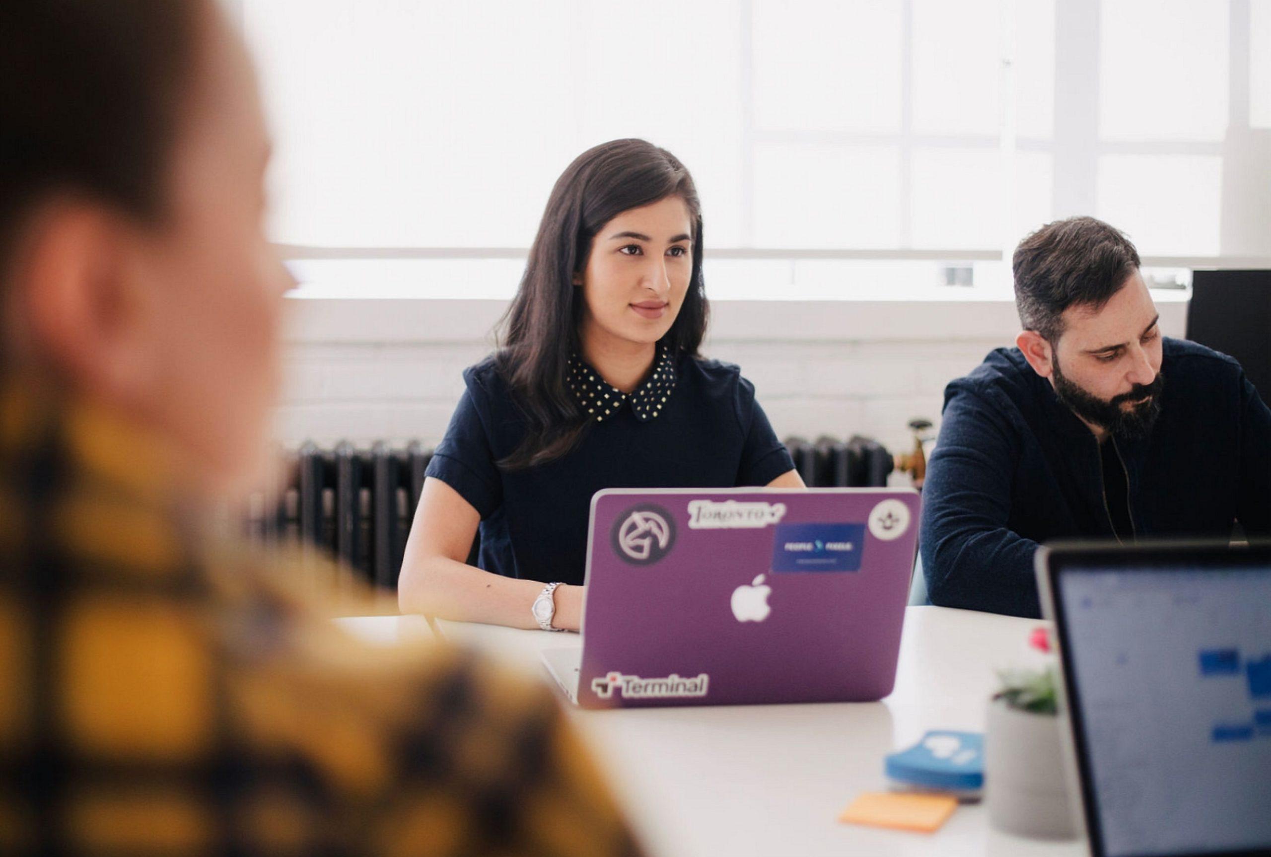 Woman in a conference room on her computer | The Neat Company blog - resources for small business