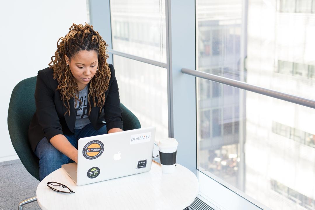 Woman sitting at her laptop in a highrise building